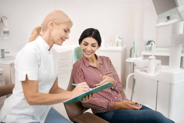 Patient telling her dentist information about herself. - Foto, Imagem