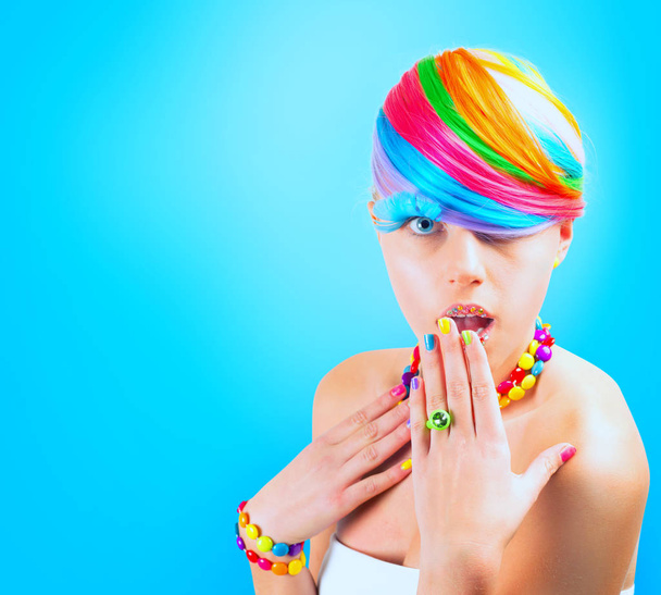 青い背景に虹のカラフルなファッションメイクを持つ女の子 - 写真・画像