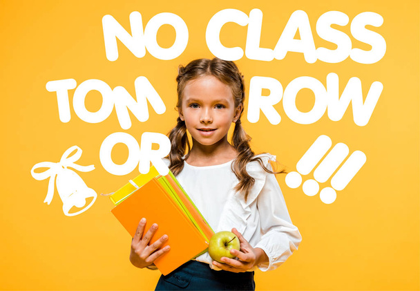 boldog iskolás gazdaság ízletes alma és könyvek közelében nem osztály holnap betűkkel a narancs  - Fotó, kép