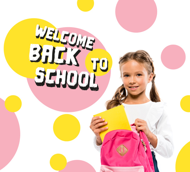 smiling child putting book in pink backpack near back to school lettering on white  - Foto, immagini