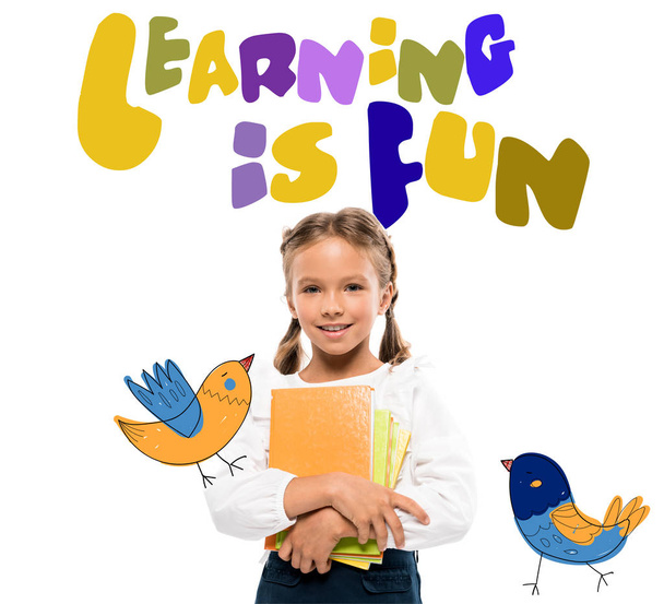 happy schoolkid holding books near learning is fun lettering on white  - Foto, imagen