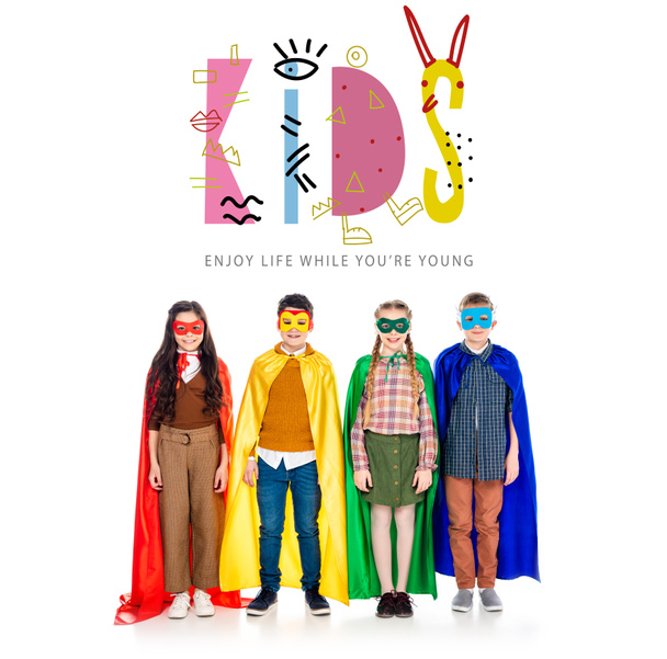 happy kids in superhero costumes and masks looking at camera near kids lettering on white - Foto, Imagen