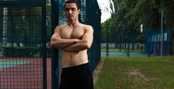 Un ragazzo caucasico muscolare che riposa sul campo sportivo
  - Foto, immagini
