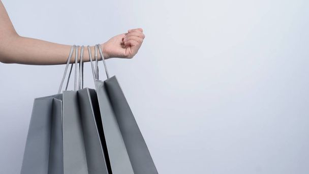 Bolsa de compras de color gris agarre en el brazo de la mujer y fondo blanco
 - Foto, Imagen