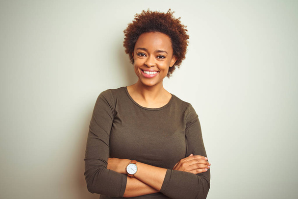 Fiatal gyönyörű afro-amerikai nő afro hajú, elszigetelt háttér boldog arca mosolyogva keresztbe karját nézi a kamerát. Pozitív személy. - Fotó, kép