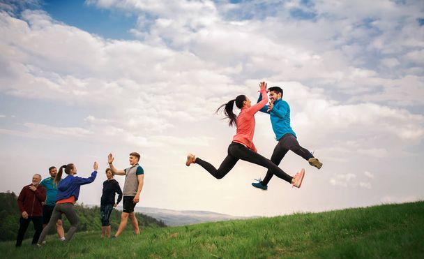 Suuri joukko kunnon ja aktiivisia ihmisiä hyppää harjoituksen jälkeen luonnossa
. - Valokuva, kuva