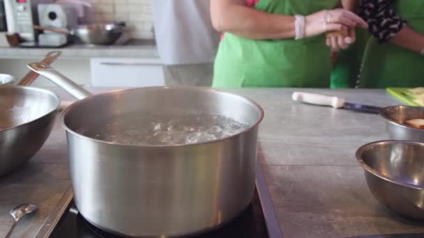 élelmiszer-főzés. étkezés előkészítése az étterem konyhája. serpenyőben forrásban lévő vízzel 4k. - Felvétel, videó