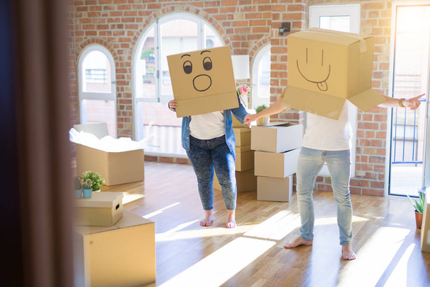 Τρελό ζευγάρι φορώντας κουτιά από χαρτόνι με αστείο emoji πρόσωπα πάνω - Φωτογραφία, εικόνα