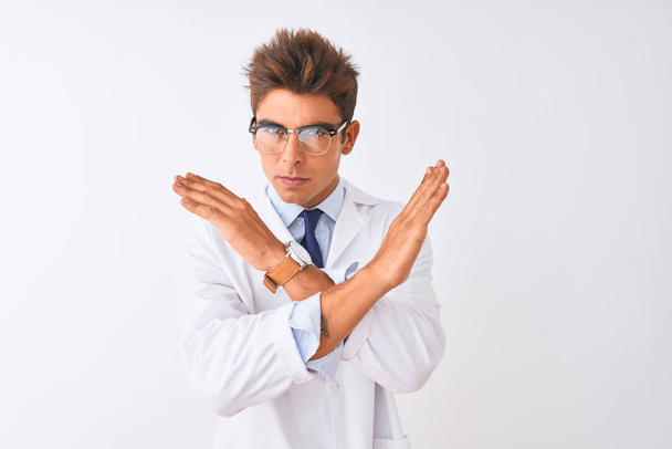 Jeune homme beau scienciste portant lunettes et manteau sur fond blanc isolé Expression de rejet croisant les bras faisant signe négatif, visage en colère
 - Photo, image