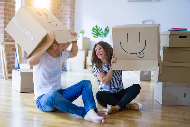 Ζευγάρι φορώντας αστεία κουτιά από χαρτόνι με χαρούμενα πρόσωπα - Φωτογραφία, εικόνα