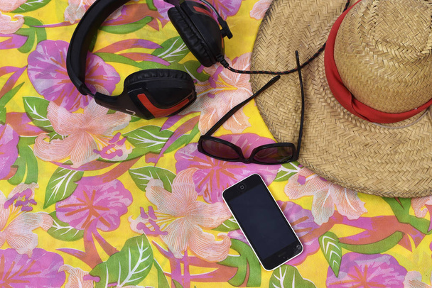 καπέλο γυαλιά τηλέφωνο και ακουστικά πάνω από το μοτίβο πανί - Φωτογραφία, εικόνα