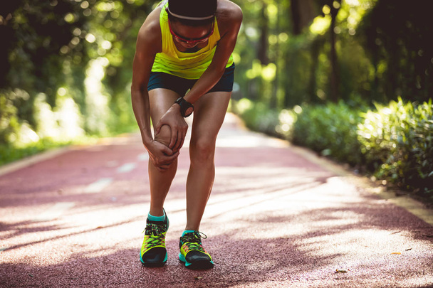 Naisjuoksija kärsii urheiluvamma käynnissä
  - Valokuva, kuva