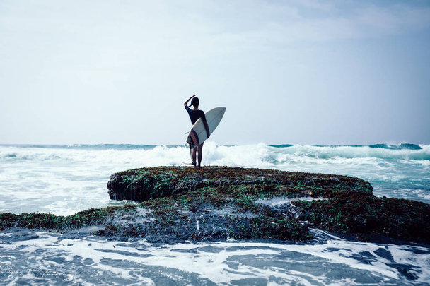 Woman surfer with surfboard going to surf - 写真・画像