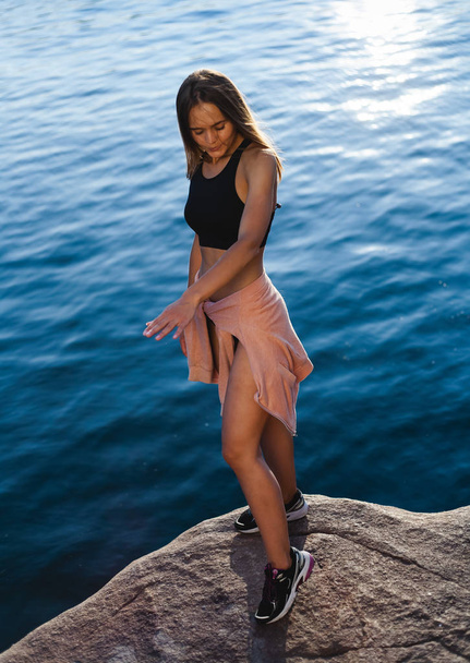 Menina bonita, atlética em tênis. Ao ar livre em uma área rochosa da ilha
. - Foto, Imagem