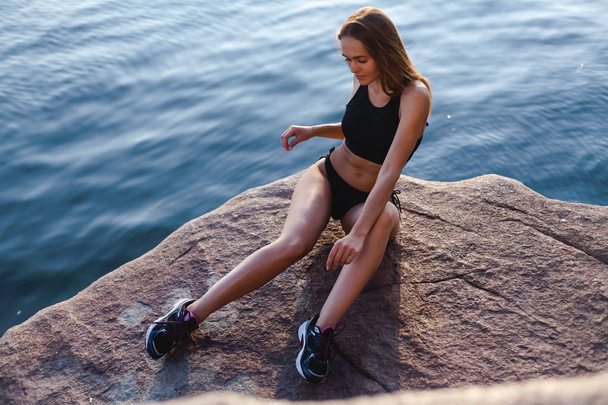 Beautiful, athletic girl in sneakers. Outdoors in a rocky area of the island. - Fotoğraf, Görsel