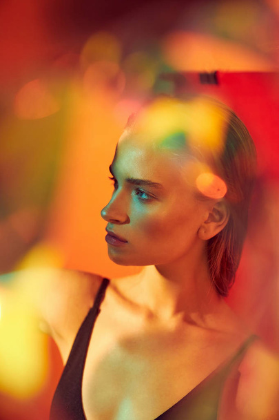 Fashion art portrait of young and sexy female model posing in multicolor lights - Fotoğraf, Görsel