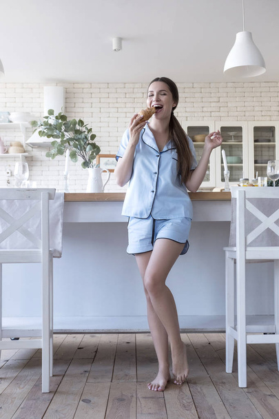 schöne fit brünette Frau zu Hause im Pyjama. sie isst Pause - Foto, Bild