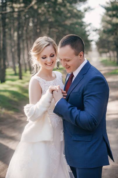 Beautiful and young bride and groom posing  in park - Zdjęcie, obraz