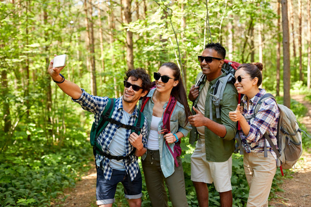 friends with backpacks hiking and taking selfie - Foto, Imagem