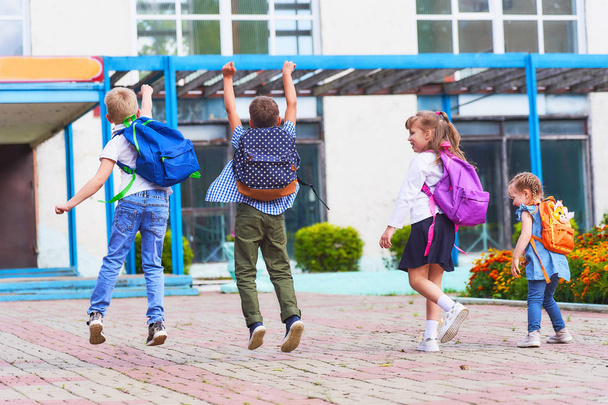 een groep studenten springen graag rond de school. - Foto, afbeelding