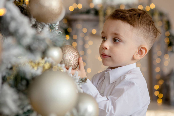 mały chłopiec zdobi choinkę na Boże Narodzenie - Zdjęcie, obraz