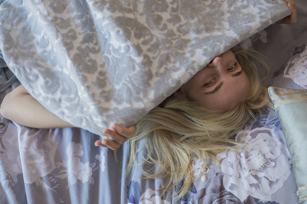 Портрет красивої молодої дівчини на ліжку в сучасній квартирі вранці
. - Фото, зображення