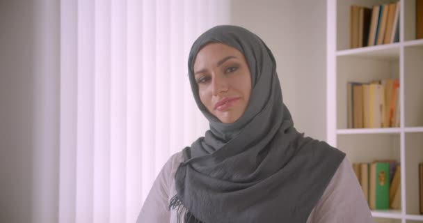 Closeup portrait of young attractive muslim businesswoman in hijab looking at camera smiling happily in office indoors - Video, Çekim