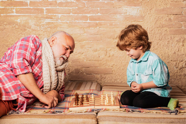 Chess hobbies - granddad with grandson on a playing chess. - Фото, изображение
