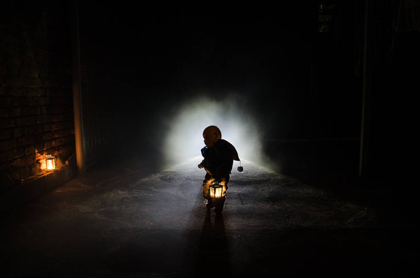 Сцена ужаса страшного детского призрака, силуэт страшной куклы на темном туманном фоне со светом
. - Фото, изображение