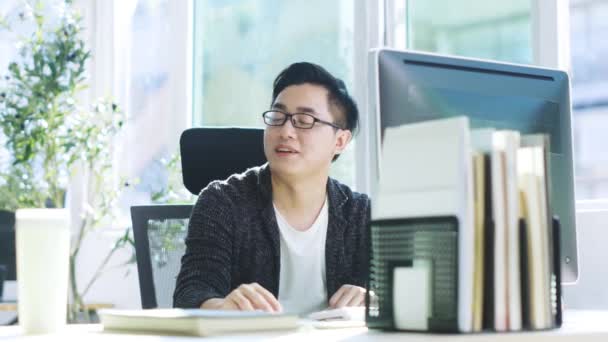 fiatal ázsiai üzletember szerzés segítséget munkatársa hivatalban - Felvétel, videó