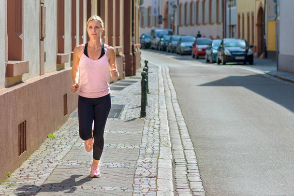 Young fit vrouw joggen in de stad - Foto, afbeelding