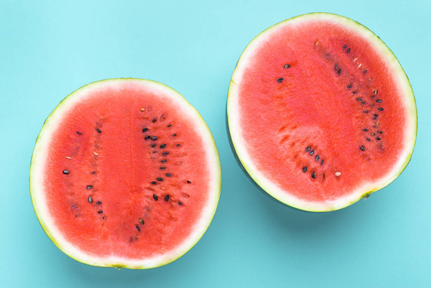 Colorful fruit background of fresh watermelon halves on blue background - Foto, afbeelding
