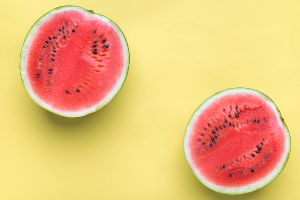 Colorful fruit minimal background of fresh juicy watermelon slices on yellow background - Photo, image