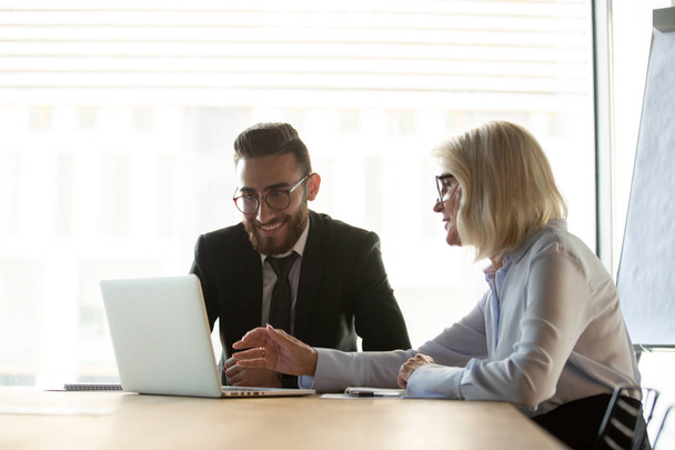 Mentor femme d'affaires mature aidant un nouvel employé avec un logiciel d'entreprise
 - Photo, image