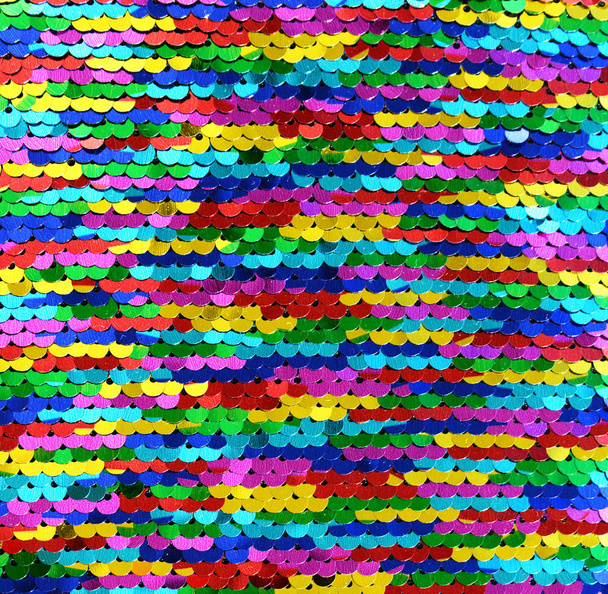 Lentejuelas macro de primer plano. Fondo abstracto con lentejuelas multicolores en la tela. Textura escamas de lentejuelas arcoiris redondas con transición de color
. - Foto, imagen
