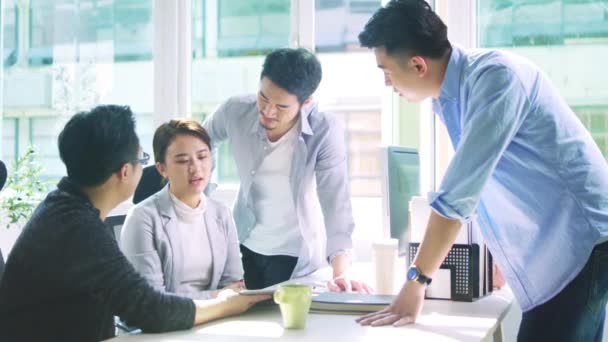 アジアの若いビジネスマン4人のグループ男女会議がオフィスで議論する - 映像、動画