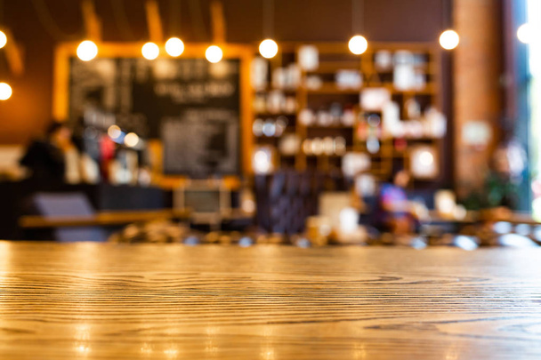 Holztisch mit verschwommenem Café-Hintergrund. Holzattrappen zur Anzeige oder Montage Ihrer Produkte. Unschärfe im Café oder Café, Hintergrund im Restaurant. - Foto, Bild