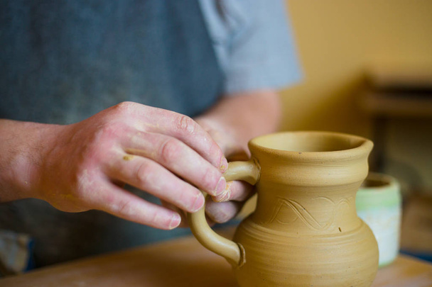 Professional male potter working in workshop, studio - Фото, изображение