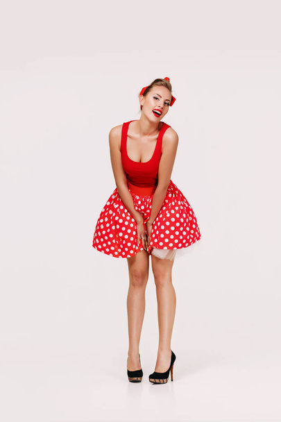 smiling pin up woman in polka dot red dress - Zdjęcie, obraz