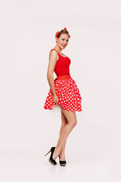 smiling pin up woman in polka dot red dress - Fotografie, Obrázek