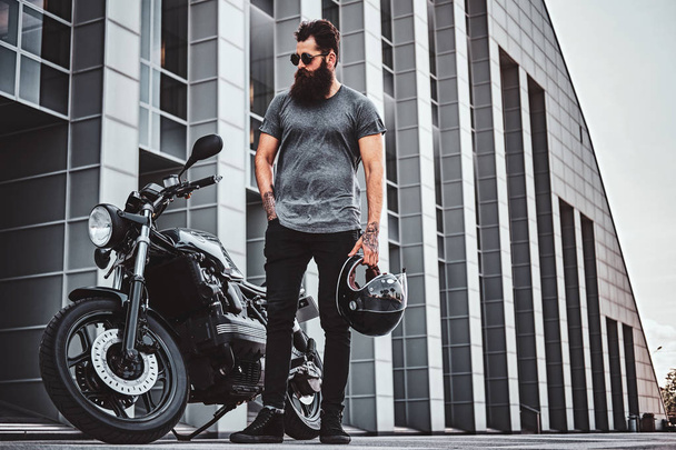 Портрет бородатого байкера, отдыхающего со своим мотоциклом
 - Фото, изображение