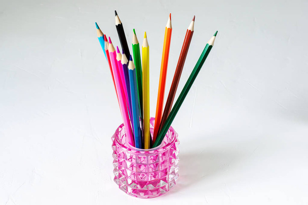 De nombreux crayons de couleur reposent sur un fond blanc. Bien reçu. L '
  - Photo, image
