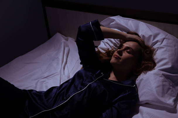 Άγρυπνη γυναίκα στο κρεβάτι στο σκοτάδι. Αϋπνία στο σπίτι έννοια. - Φωτογραφία, εικόνα