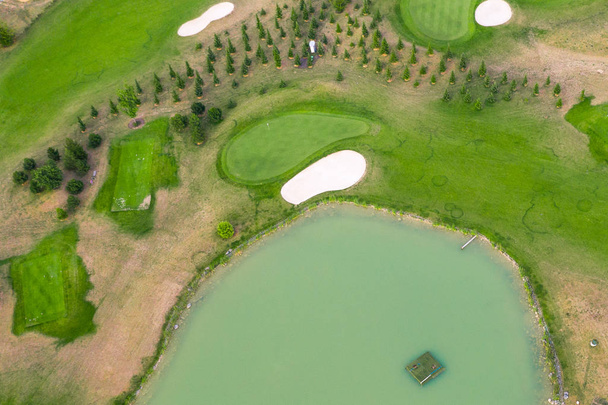 Vista aérea del campo de golf. Drone o helicóptero vista de campo verde arena bunker y peligro de agua
 - Foto, imagen