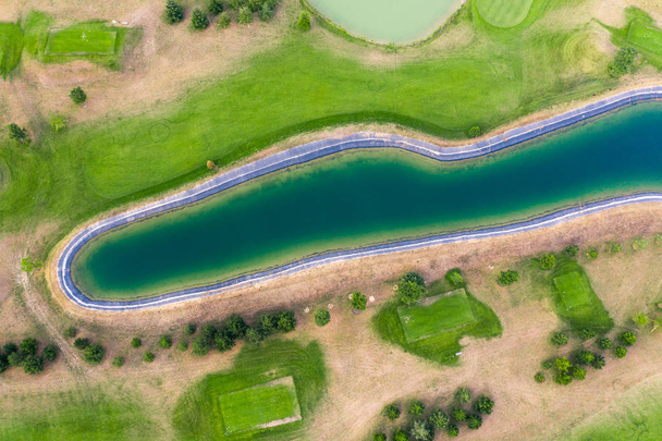 Aerial view of golf course. Drone or helicopter view of green field sand bunker and water hazard - Photo, Image