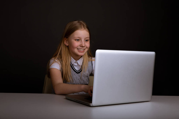 Happy Little Girl Infront laptopa wpisując na białym tle. - Zdjęcie, obraz