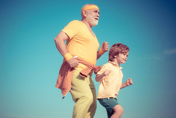 Healthcare run lifestyle. Grandfather and grandson jogging. Senior man and child in family health club. - Foto, immagini