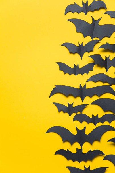 Halloween paper vampire bat decorations on an orange background. - Фото, зображення