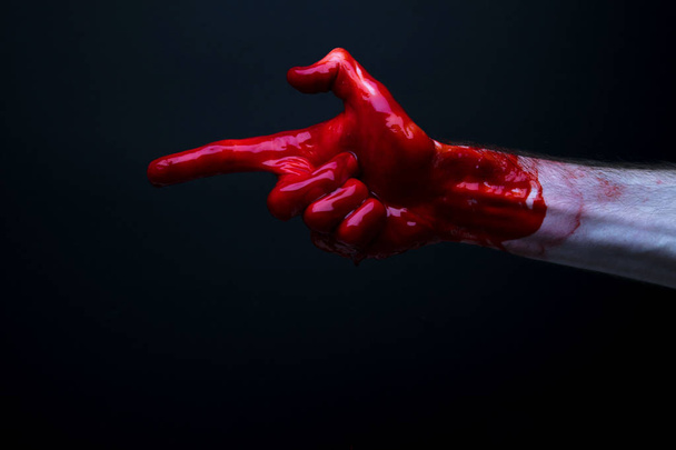 Bloody hand against a dark background. halloween horror concept - Φωτογραφία, εικόνα