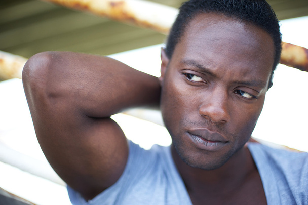 Attractive black man with hand behind head looking away - Photo, Image